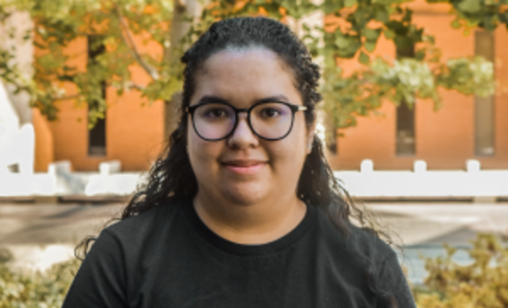 Photo of Maeve wearing glasses and a black shirt.